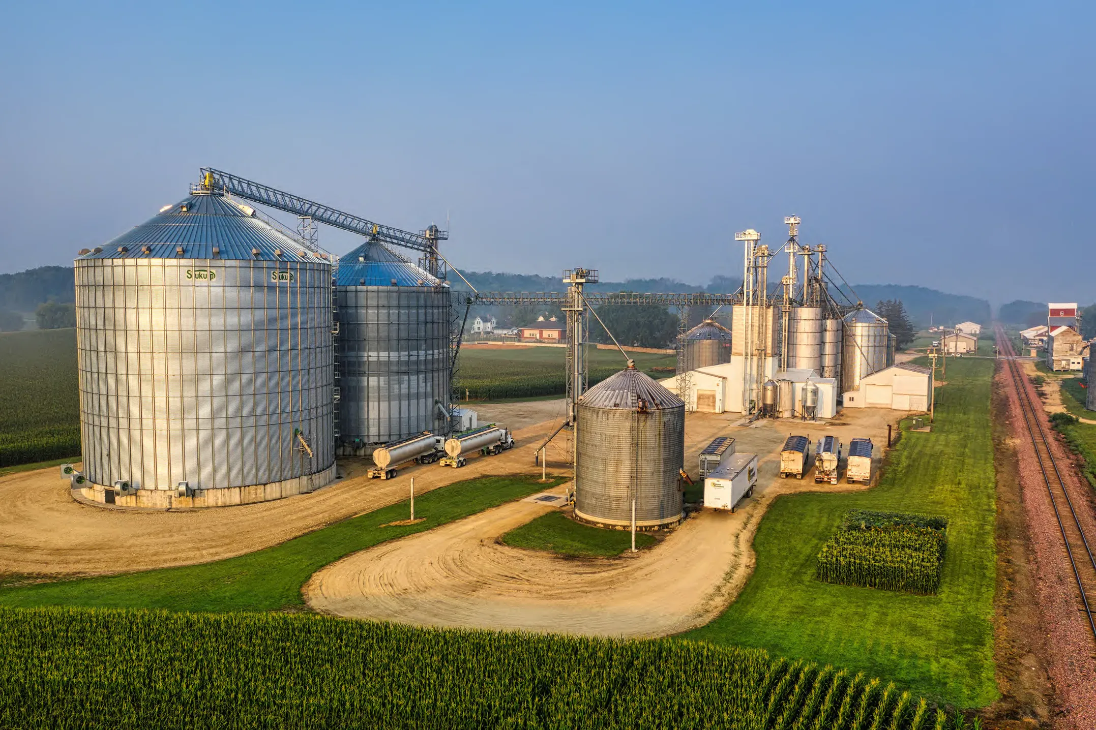 Aerial view of grain silos and agro-industrial facilities beside cultivated fields